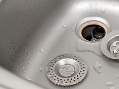 silvery-kitchen-sink-with-disassembled-protective-filter-during-repair-process_76080-8804